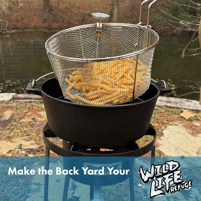 French fries in a stainless mesh fry basket being used with a cast iron pot on an outdoor cooker with text that reads Make the Back Yard your Wildlife Refuge.
