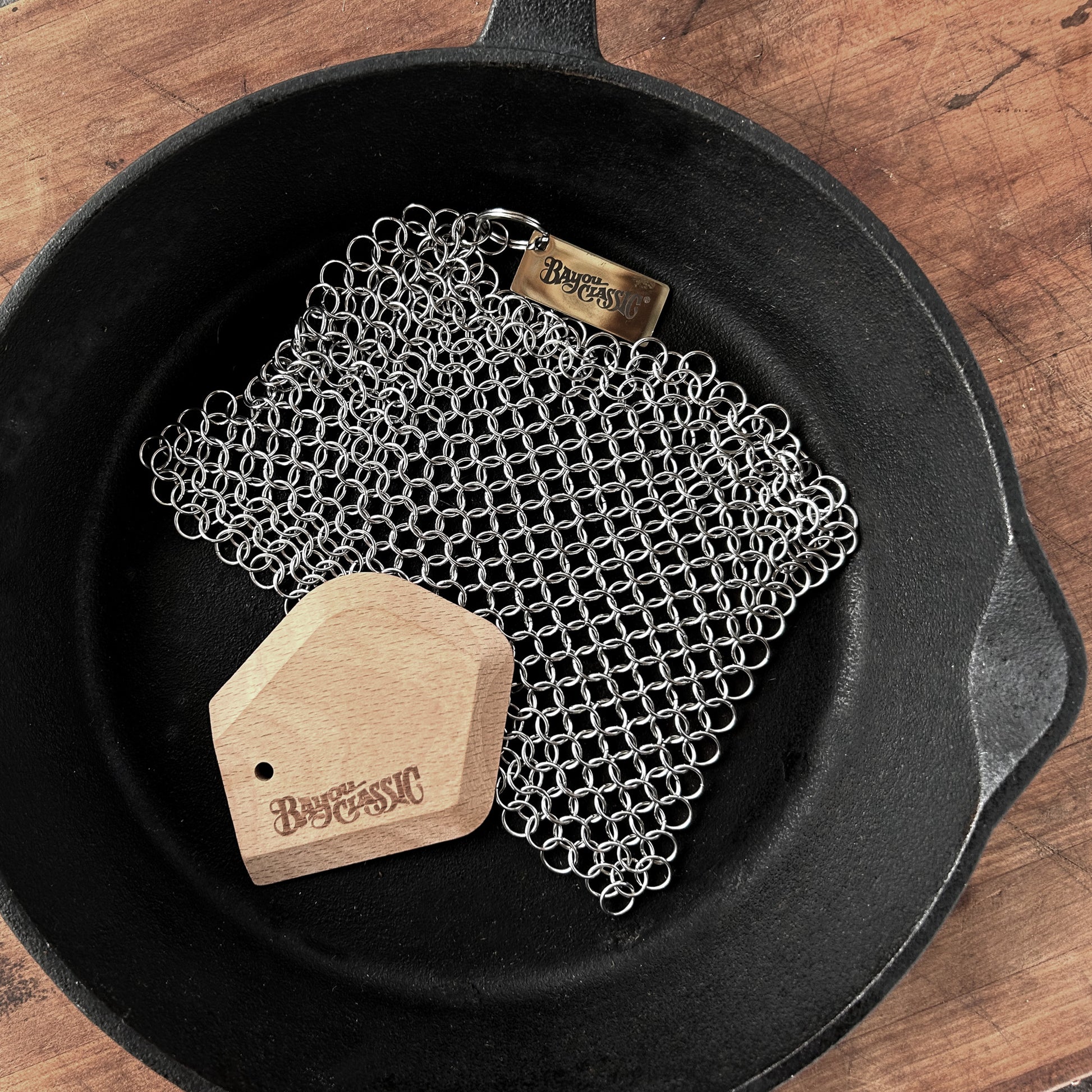 Chainmail scrubber and beech wood scrapper in a cast iron skillet