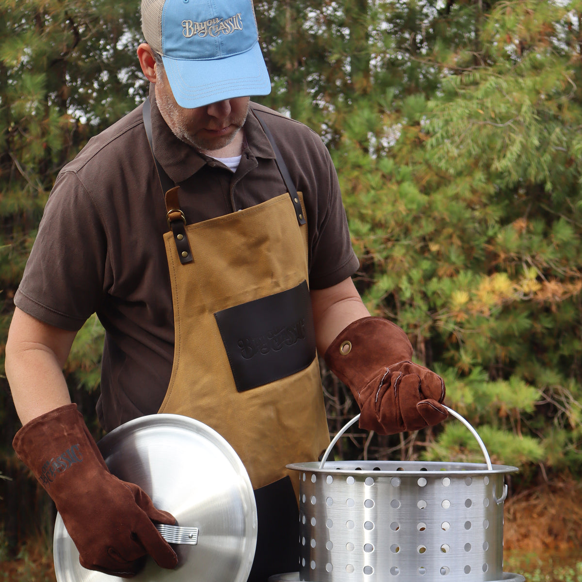 Person using brown fry gloves to hold a basket and lid outside