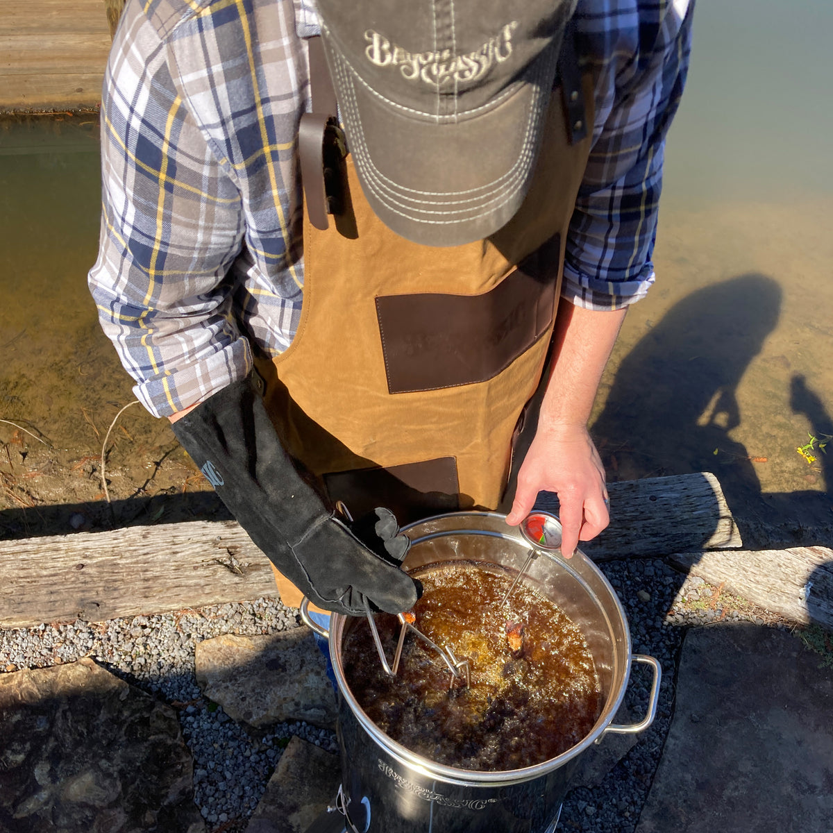 Person outside frying a turkey in a stainless turkey fryer