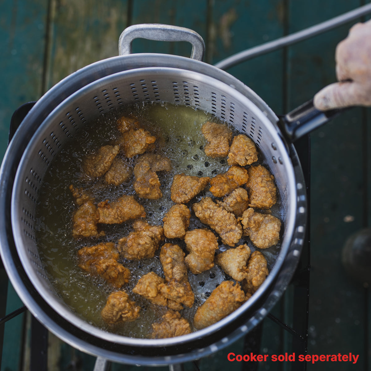 Person frying fried turkey nuggets in an aluminum fry pot. Text reads cooker sold separately.