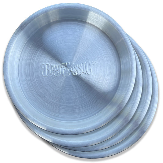 A stack of four silver aluminum serving trays with the embossed 'Bayou Classic' logo on a white background