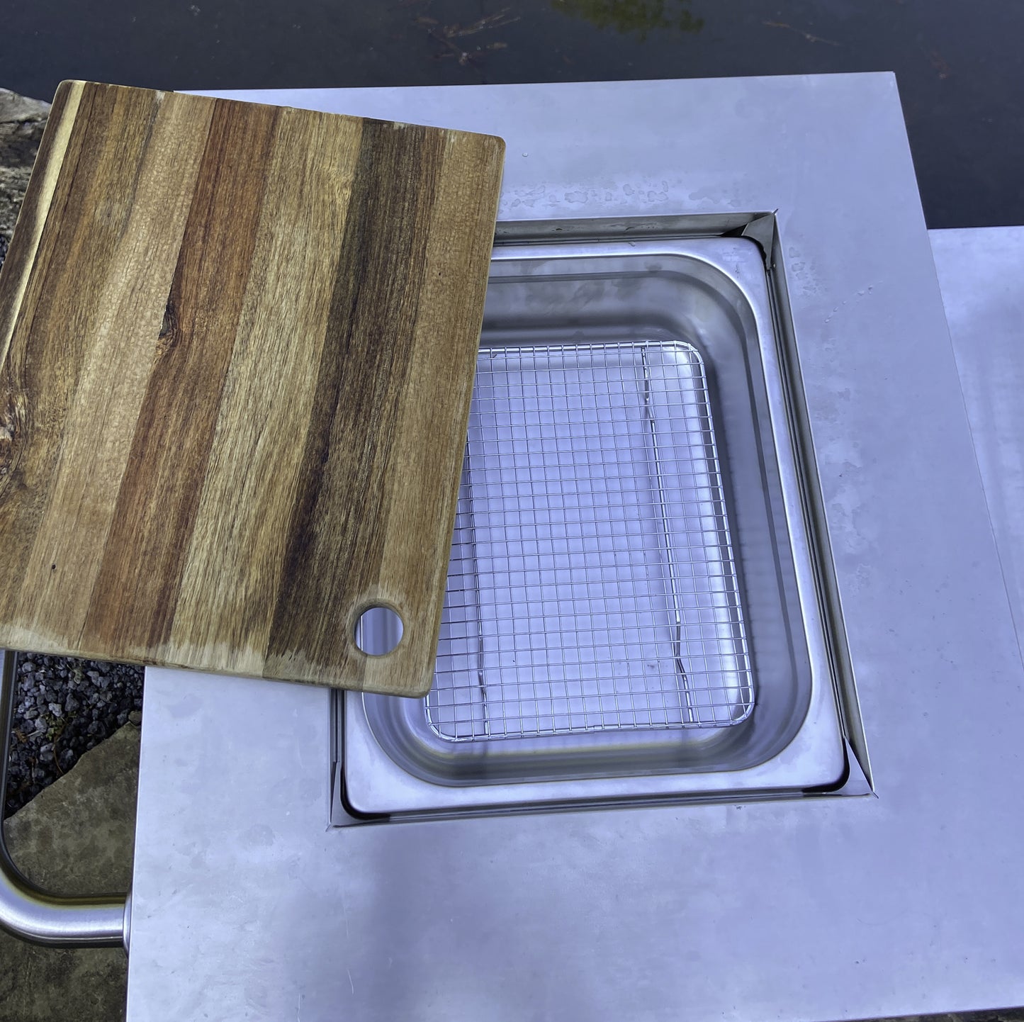 Close up view of cutting board open showing food pan underneath on 700-727 Bayou Fryer Workstation