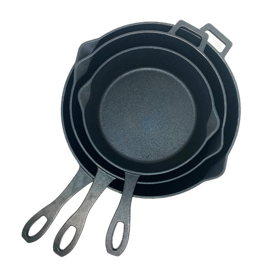 A set of three black cast iron skillets with handles, stacked together, in varying sizes on a white background