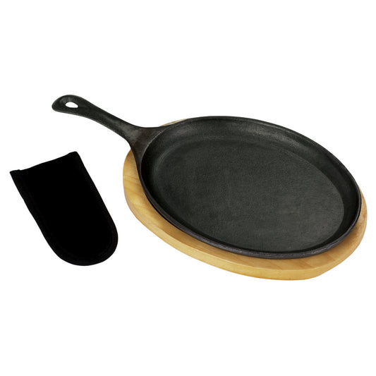 A black cast iron fajita pan with a wooden trivet and a black handle mitt on a white background