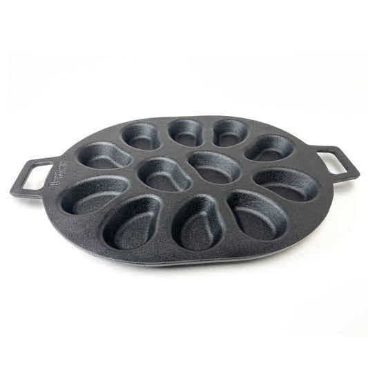 A black cast iron oyster grill pan with shellfish-shaped molds and two handles on a white background.