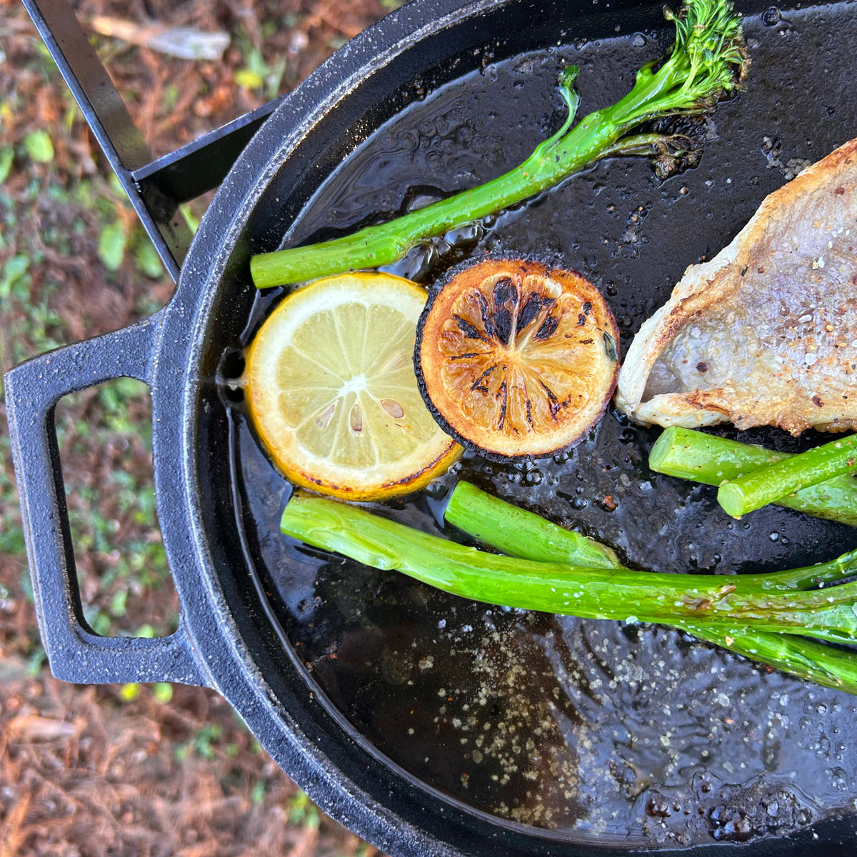 Cast Iron Oval Fryer using griddle lid to cook fish and asparagus outside