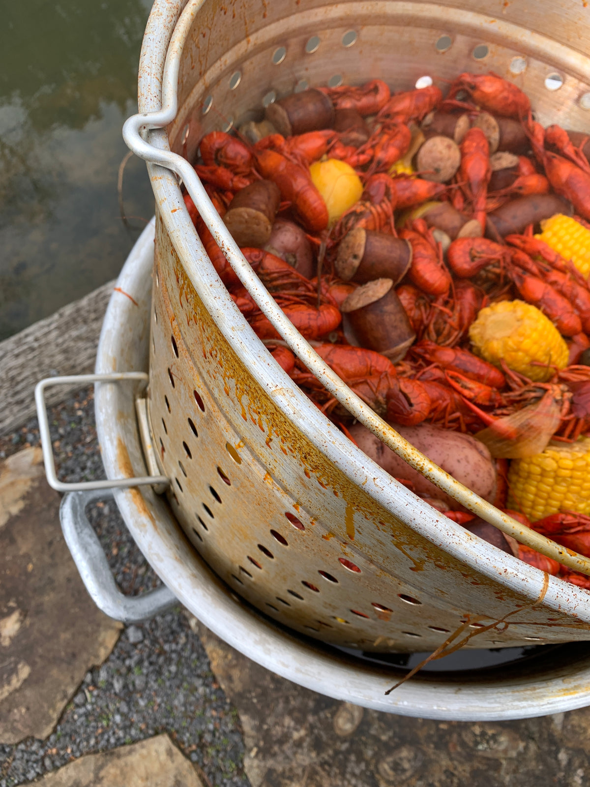 Cooked crawfish with sausage and corn in an aluminum stockpot outside