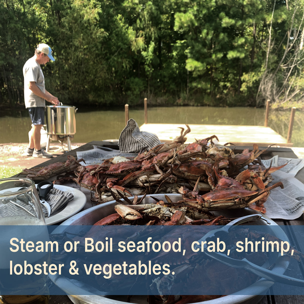Cooked crabs on table with stainless cooker kit in the background by a lake