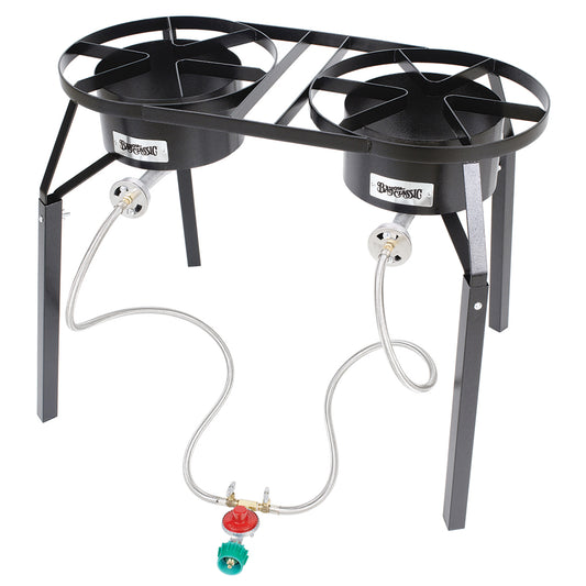 A dual burner high pressure cooker with two cast aluminum burners, stainless steel braided LPG hoses, and a black welded steel frame on a white background.