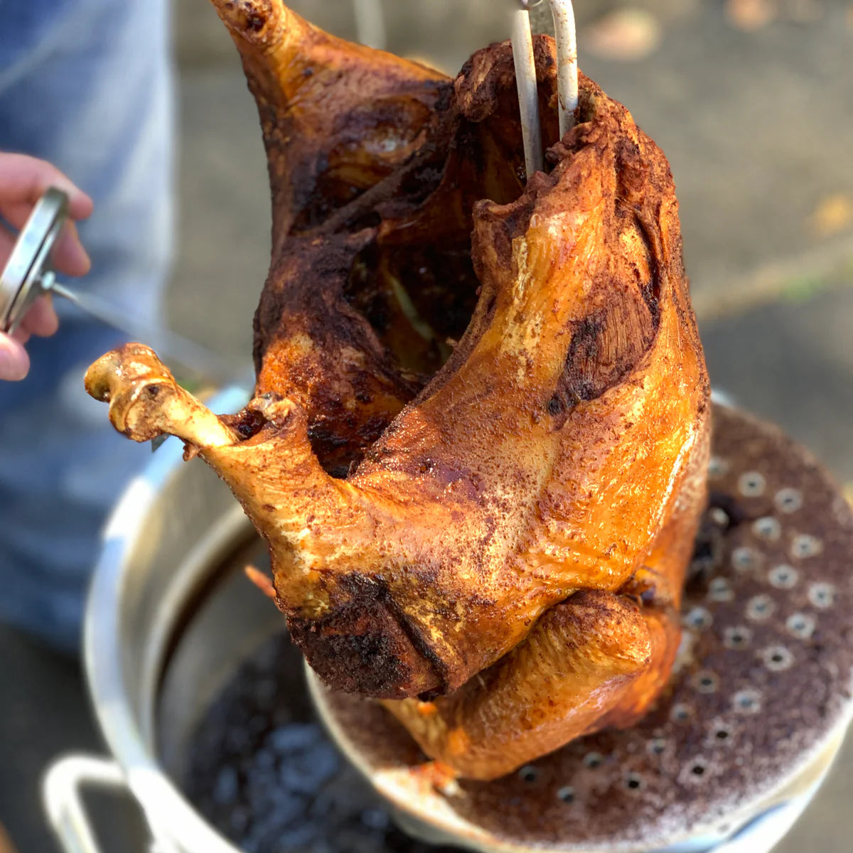 Fried Turkey on a poultry rack coming out of a turkey fryer