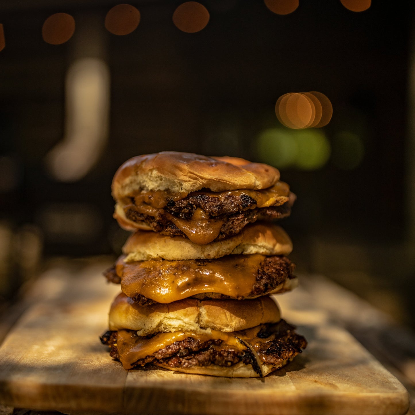 A stack of three smashburgers with cheese
