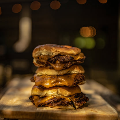 A stack of three smashburgers with cheese