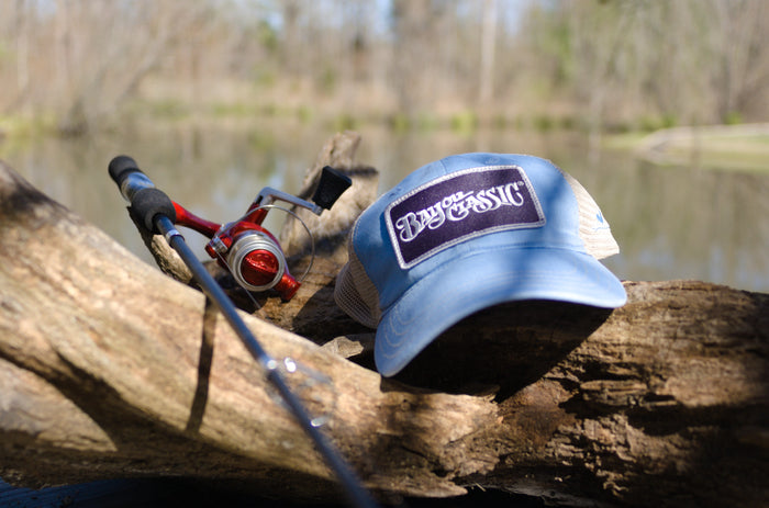 Blue cap with a logo on a log near a body of water